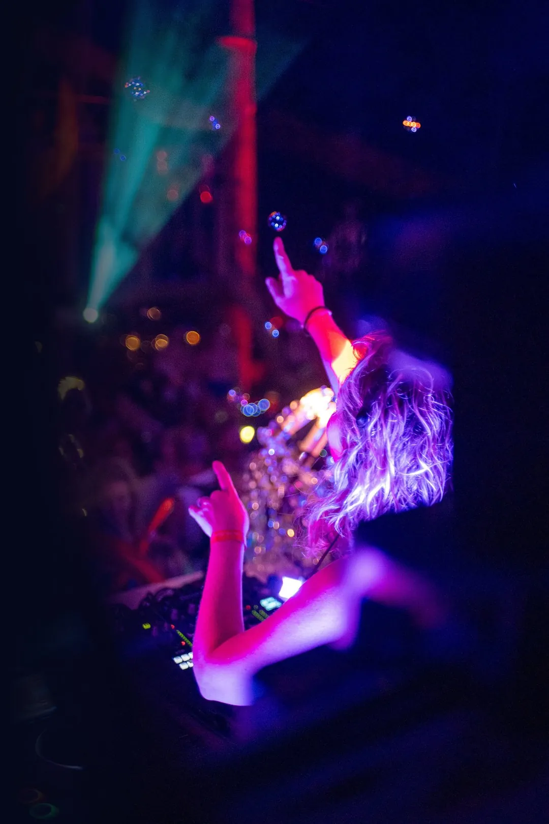 Daniela pointing up into lasers at CAMP Festival 2024