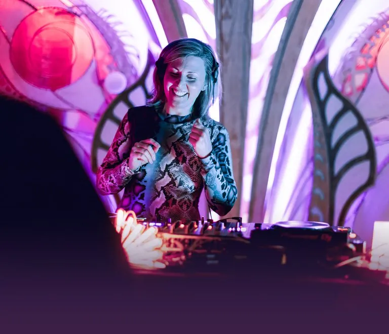 Daniela DJing in front of a hand-painted set at Her Name Is Shakti