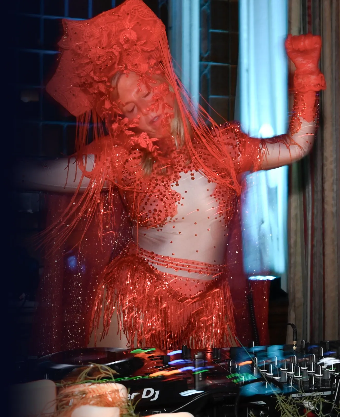 Daniela in a red headdress and veil, arms outstretched above the decks at the Mütter Museum