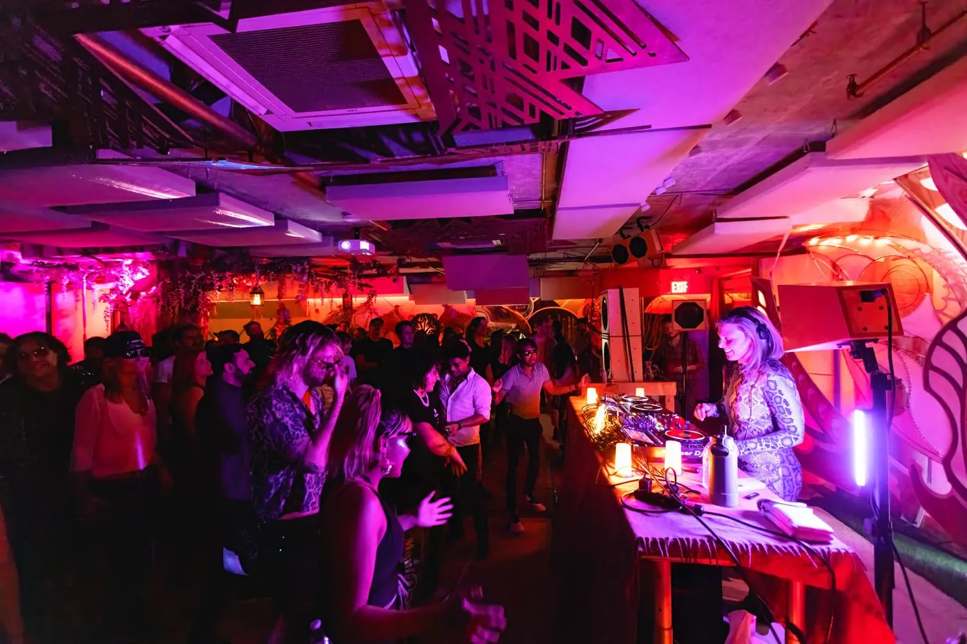 Packed dance floor under pink and purple lights at a Her Name Is Shakti event